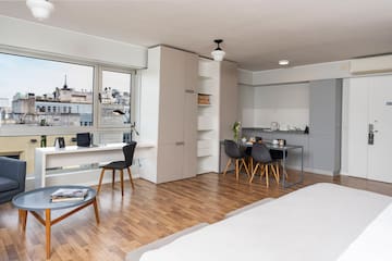 a room with a bed and a table and chairs