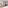 Modern studio apartment with living area, kitchen, desk, and city view.
