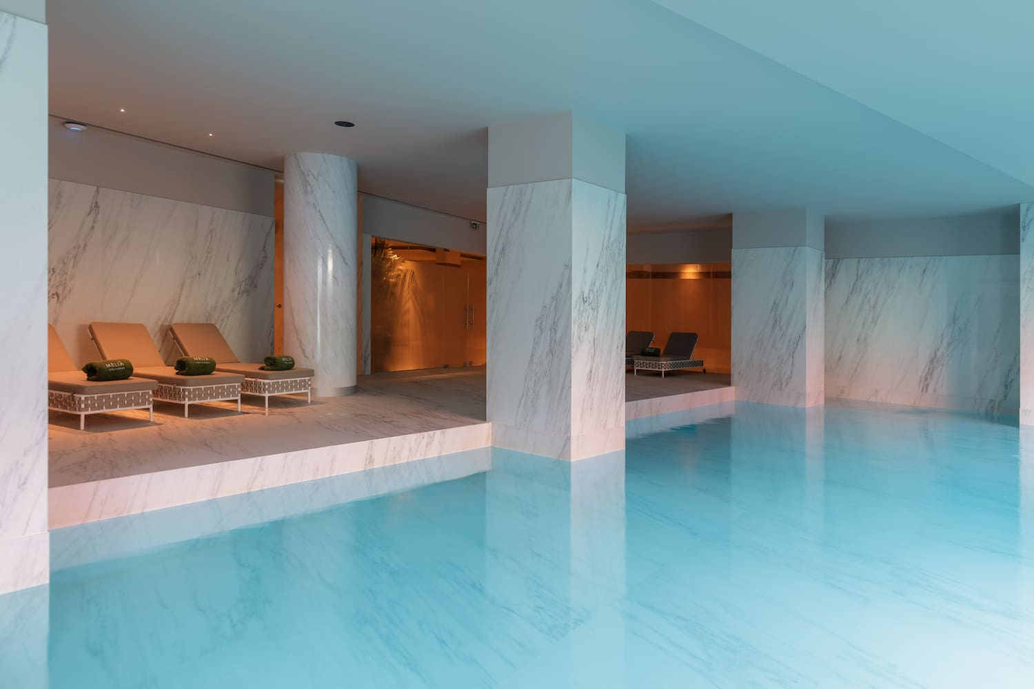 a pool with chairs and a lounge chair