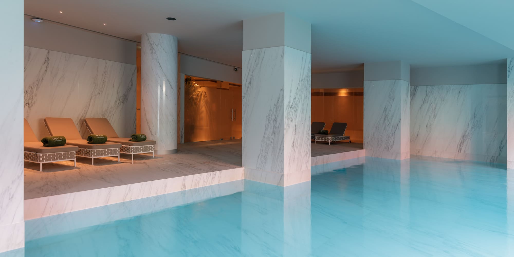 a pool with chairs and a lounge chair