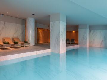 a pool with chairs and a lounge chair