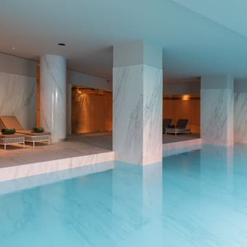 a pool with chairs and a lounge chair