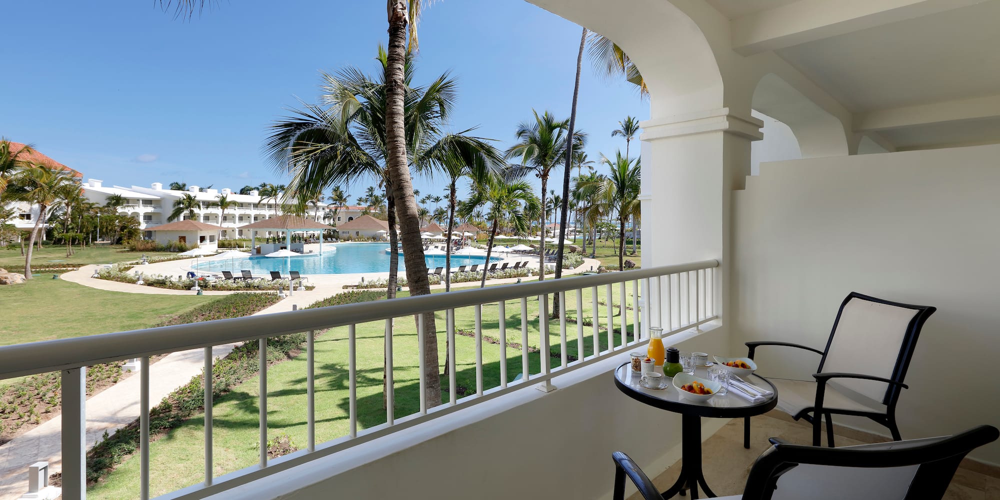 a table and chairs on a balcony overlooking a pool