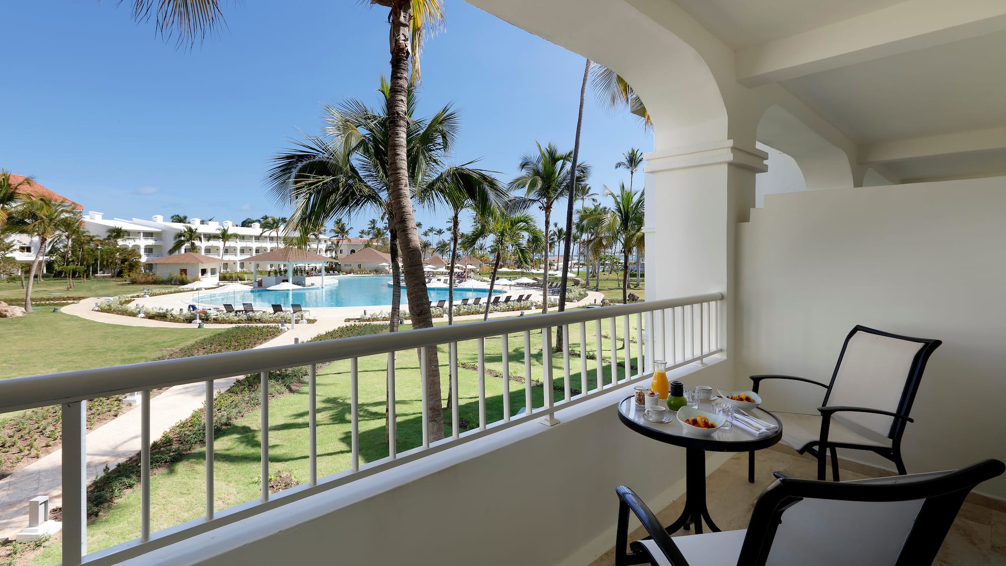 a table and chairs on a balcony overlooking a pool