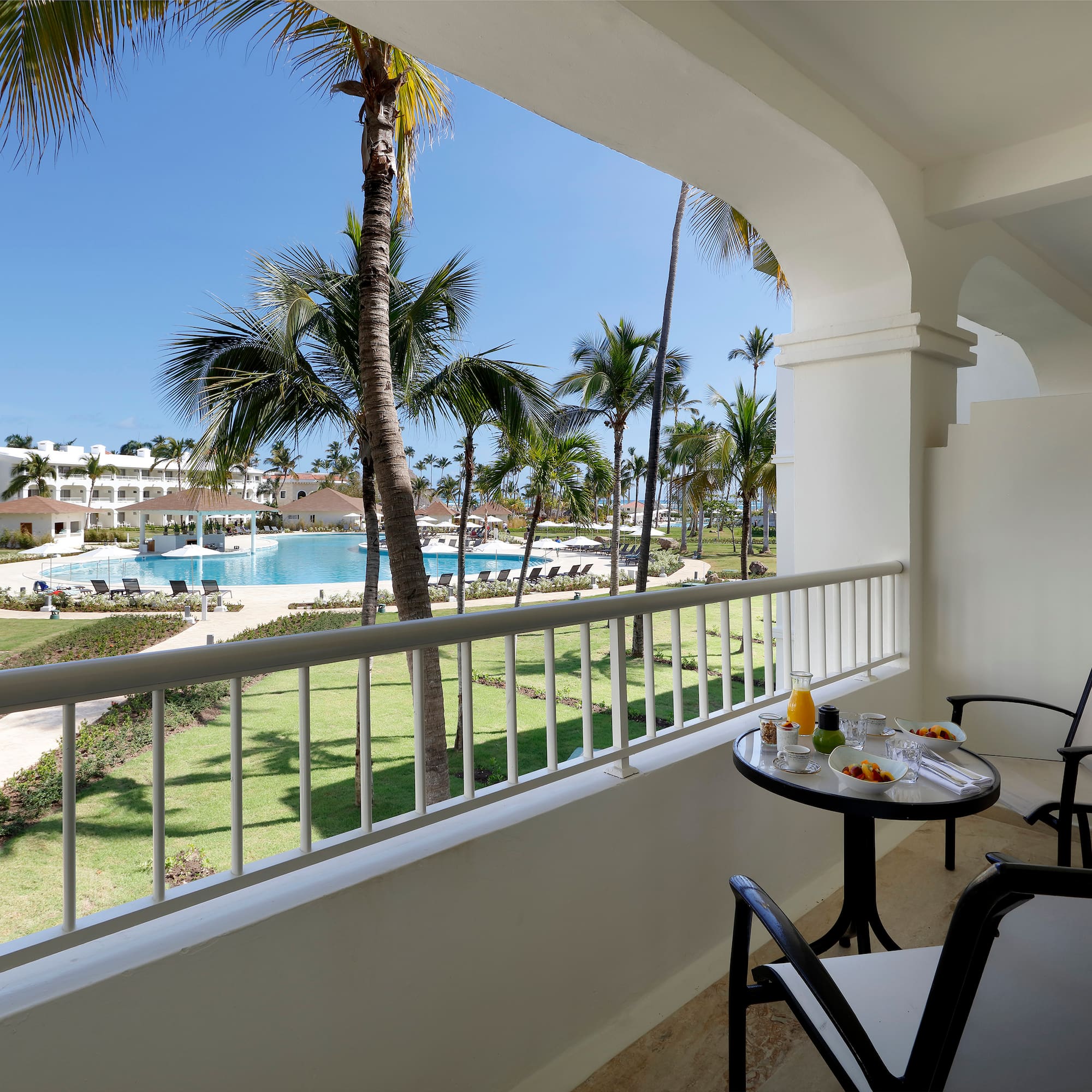 a table and chairs on a balcony overlooking a pool