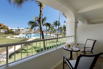 a table and chairs on a balcony overlooking a pool