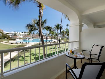 a table and chairs on a balcony overlooking a pool