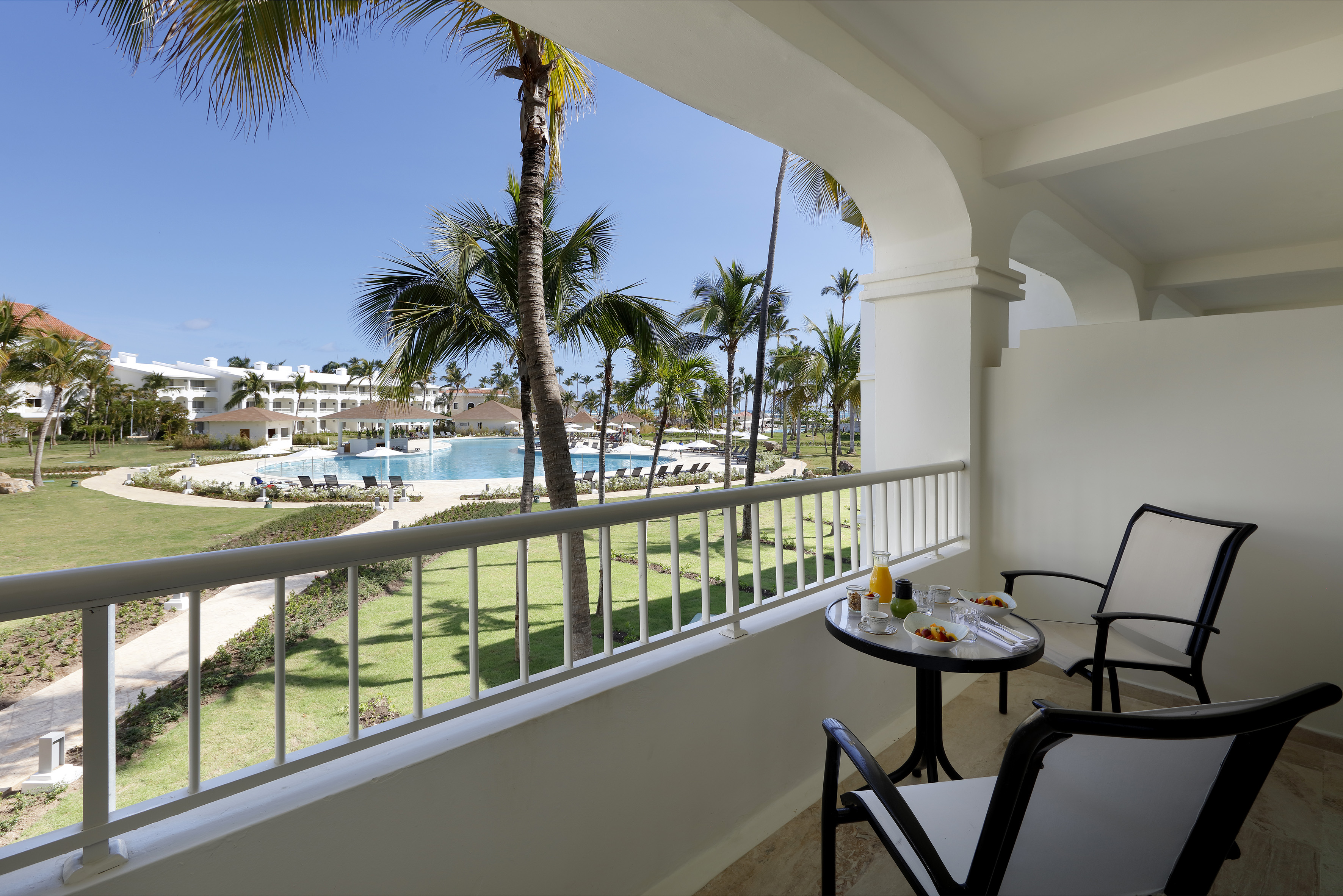 a table and chairs on a balcony overlooking a pool