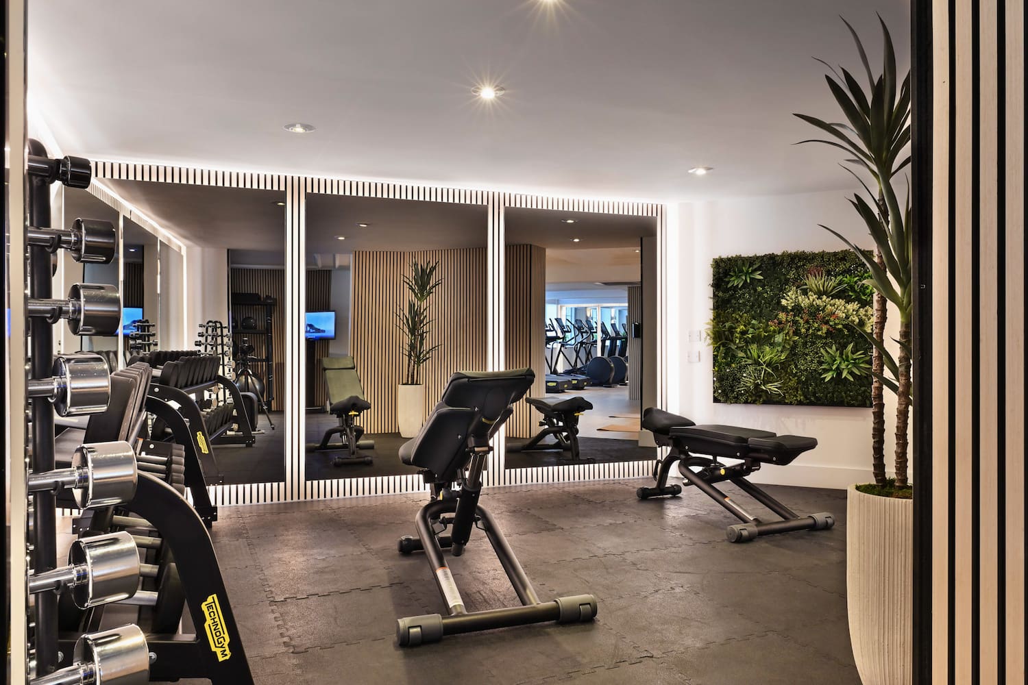 a room with exercise equipment and mirrors