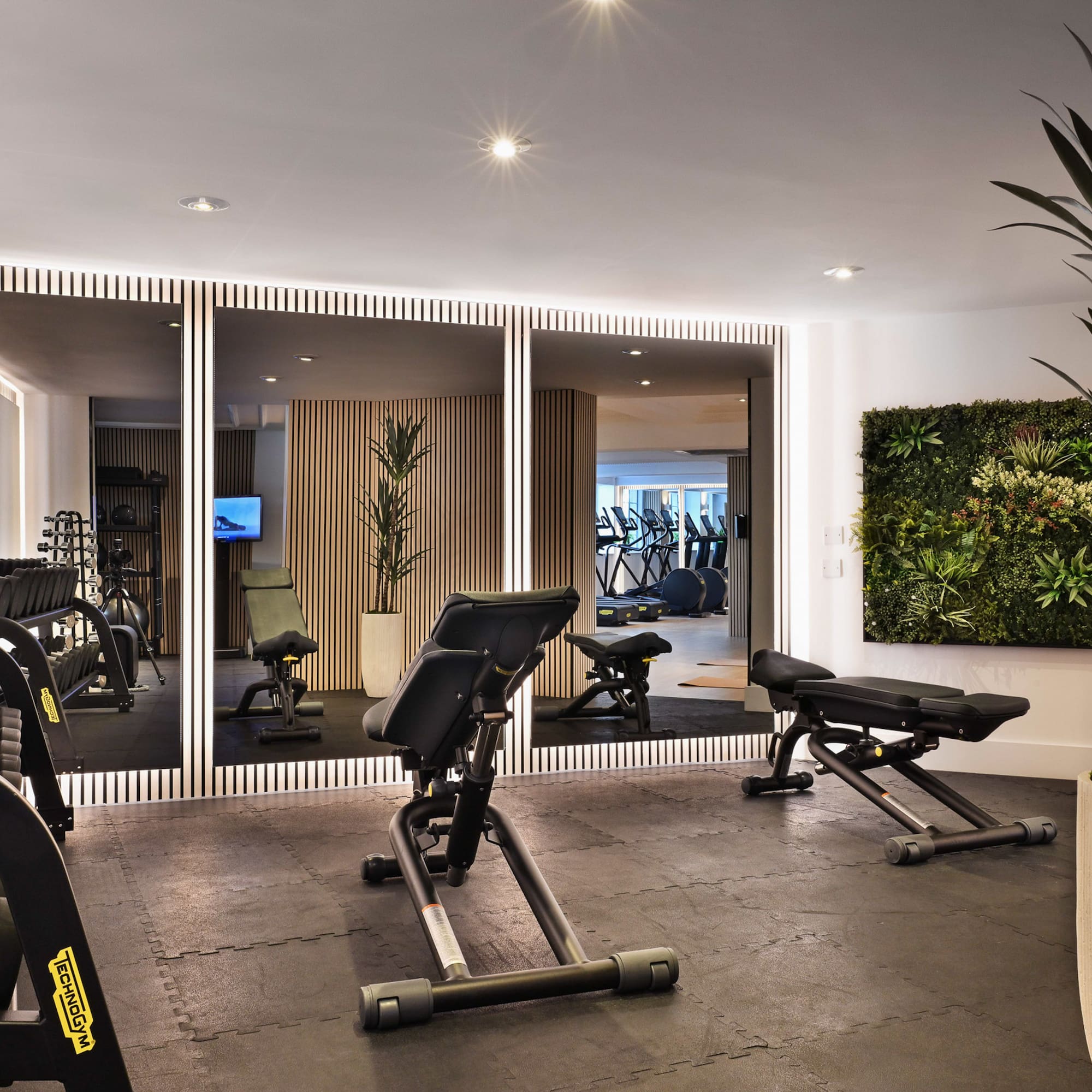 a room with exercise equipment and mirrors