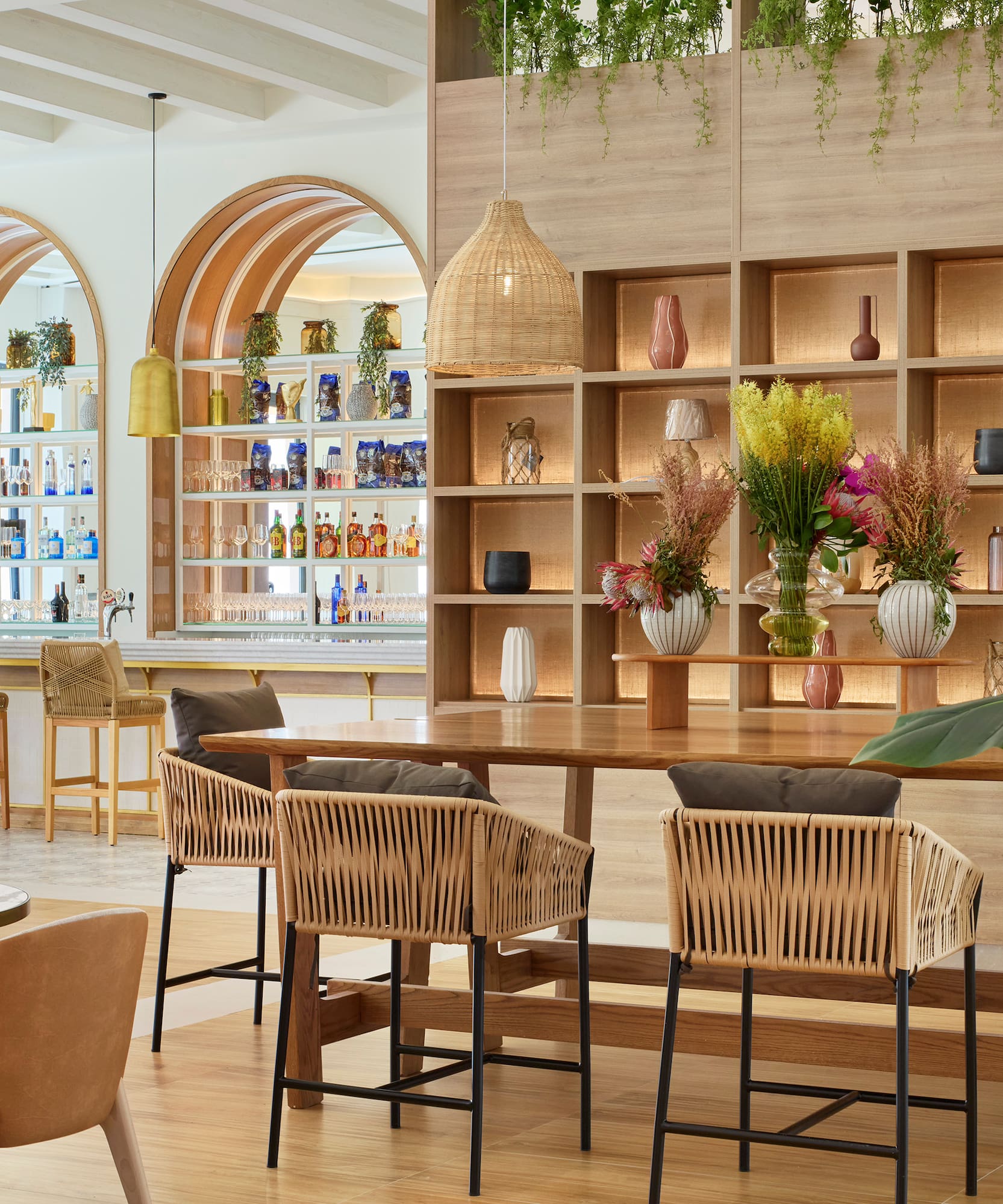 a room with a table and chairs and shelves with plants