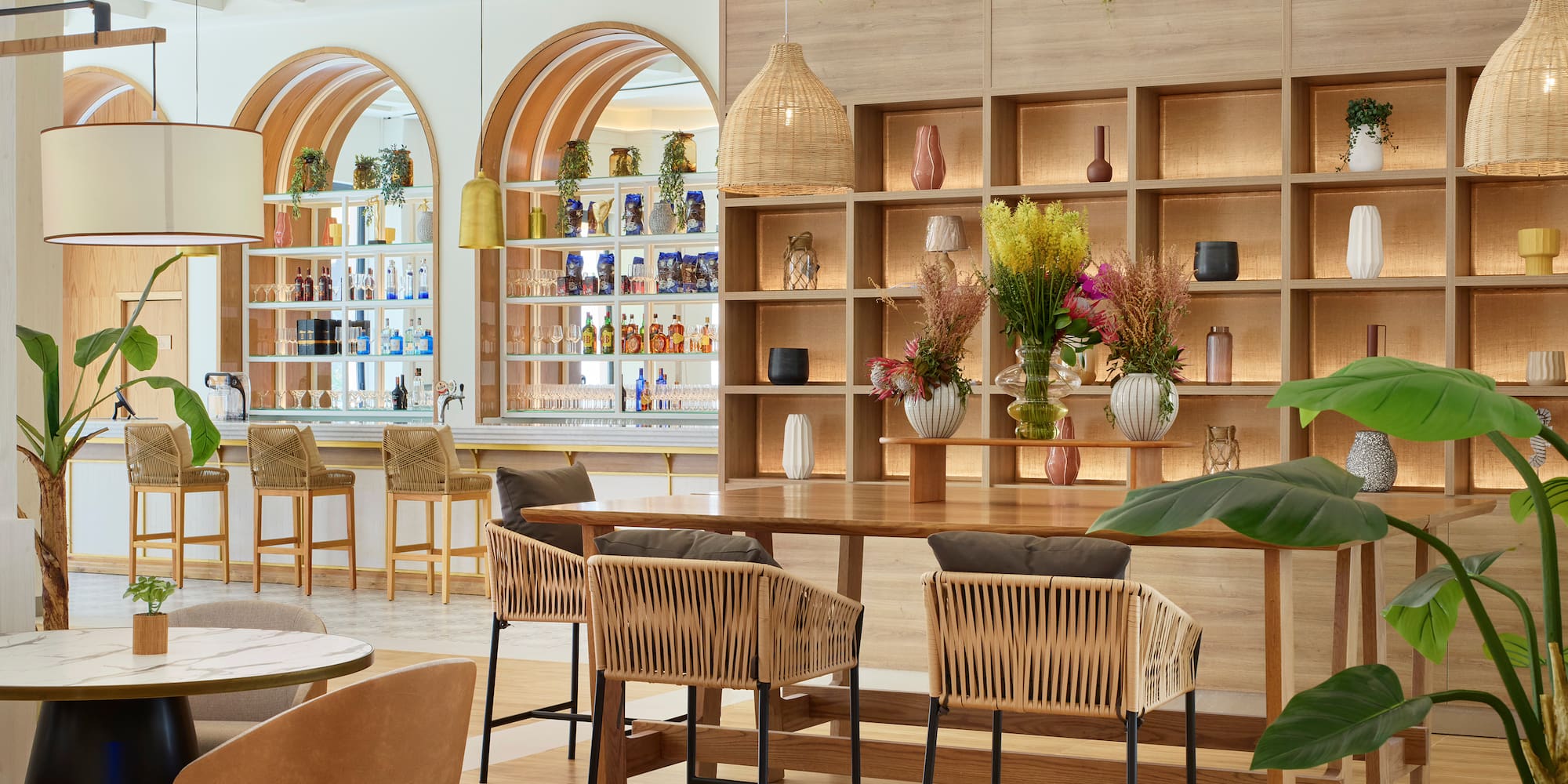 a room with a table and chairs and shelves with plants