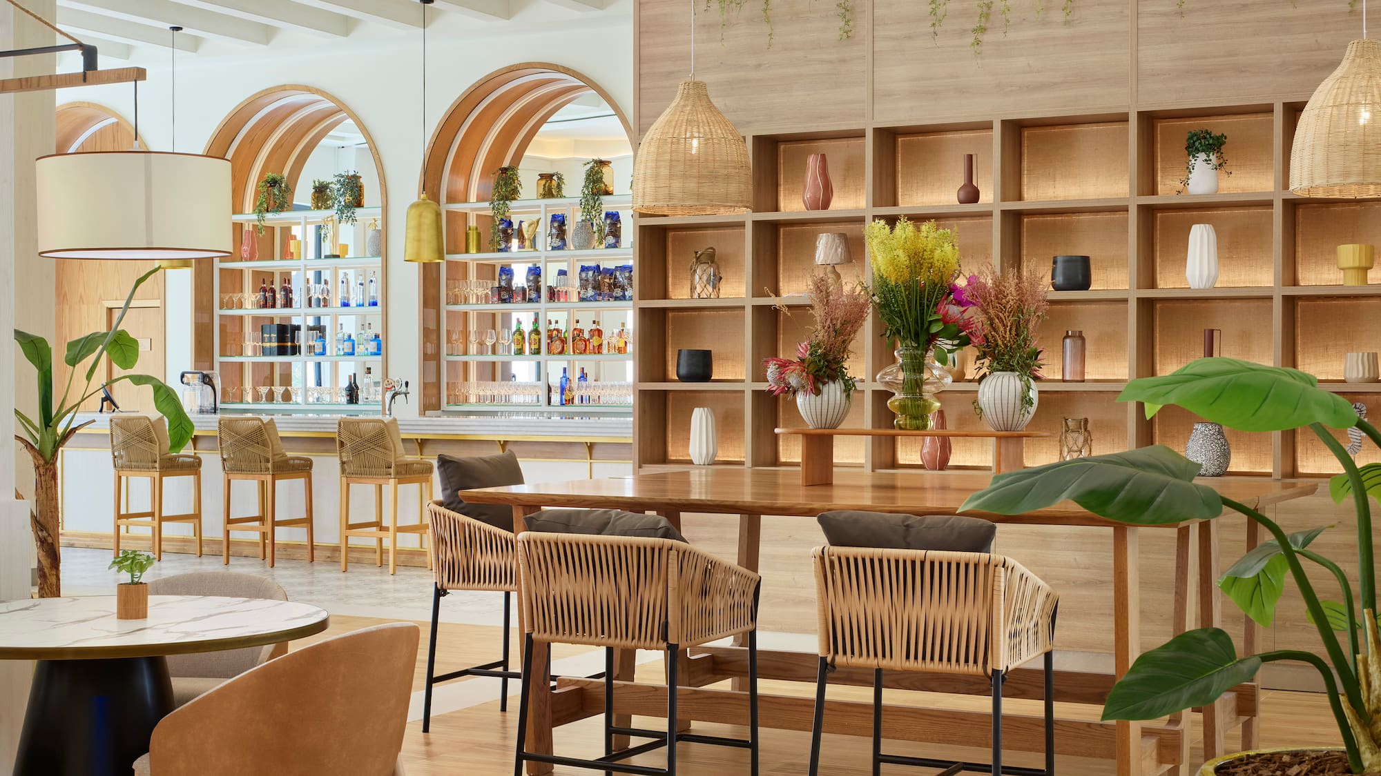a room with a table and chairs and shelves with plants