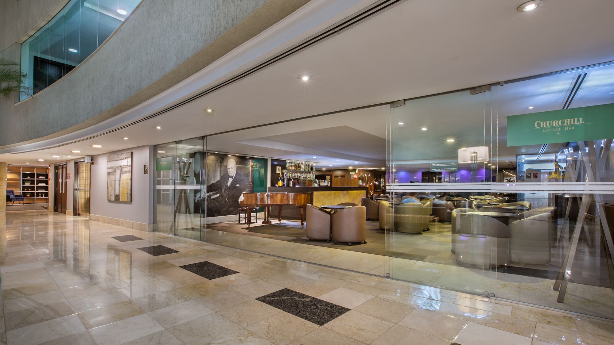 Elegant Churchill Lounge Bar in hotel, featuring piano, bar, and seating.