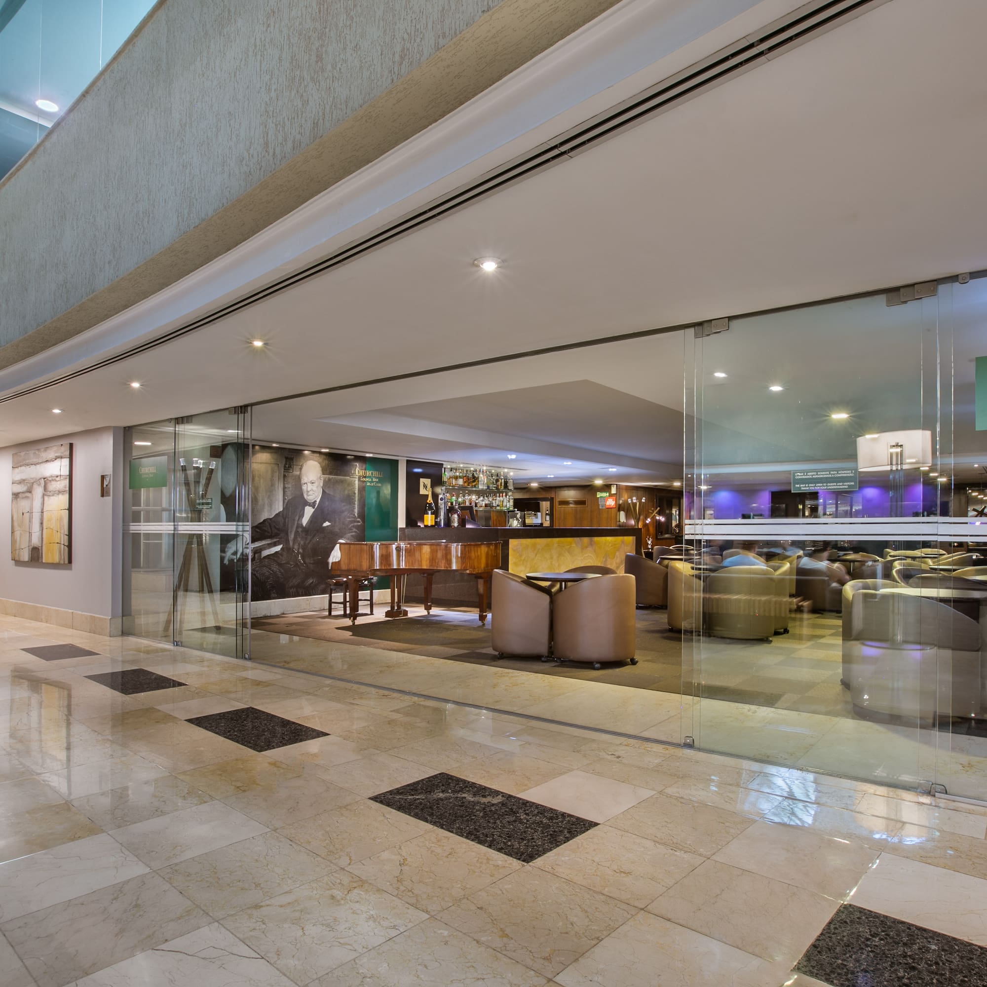 Elegant Churchill Lounge Bar in hotel, featuring piano, bar, and seating.
