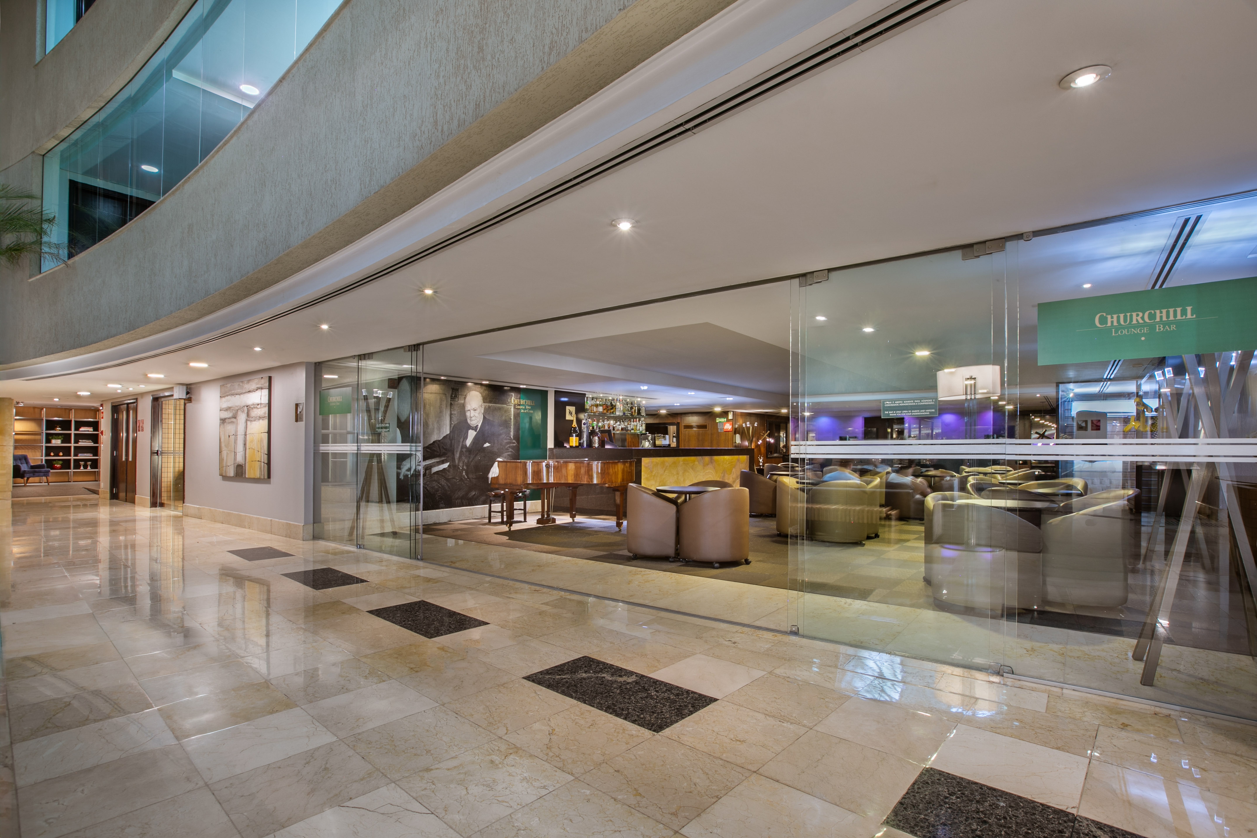 Churchill Lounge Bar entrance in a hotel lobby with piano and cozy seating.