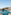 Beach resort pool with swim-up bar, lounge chairs, palm trees, and ocean.
