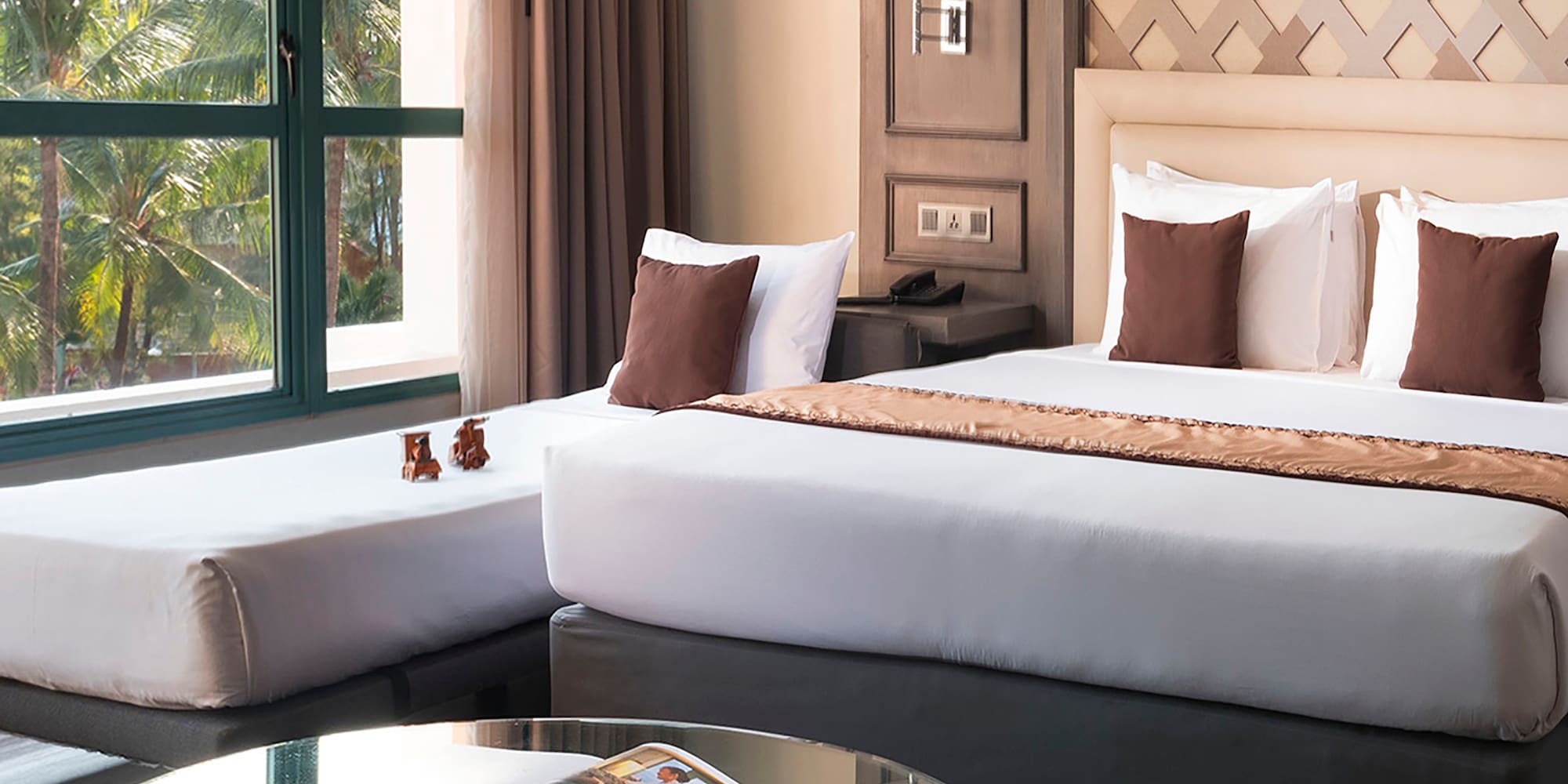 a room with two beds and a glass table