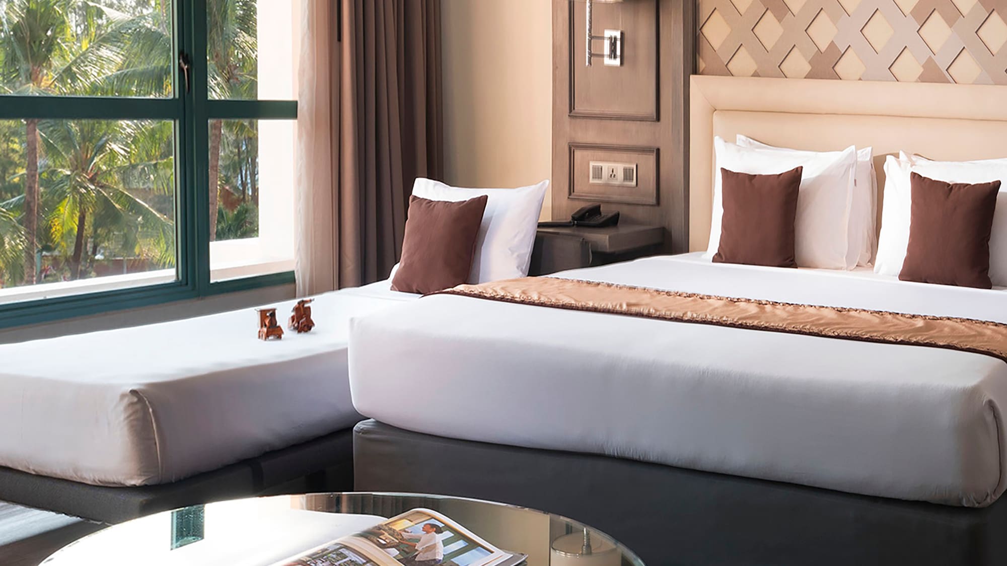 a room with two beds and a glass table