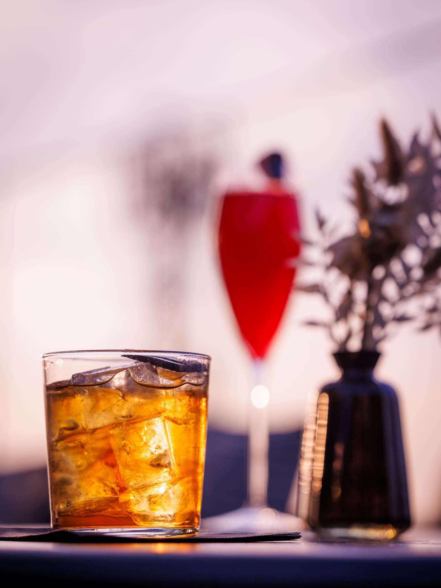 a glass of ice tea and a vase of flowers