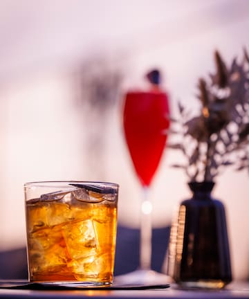 a glass of ice tea and a vase of flowers