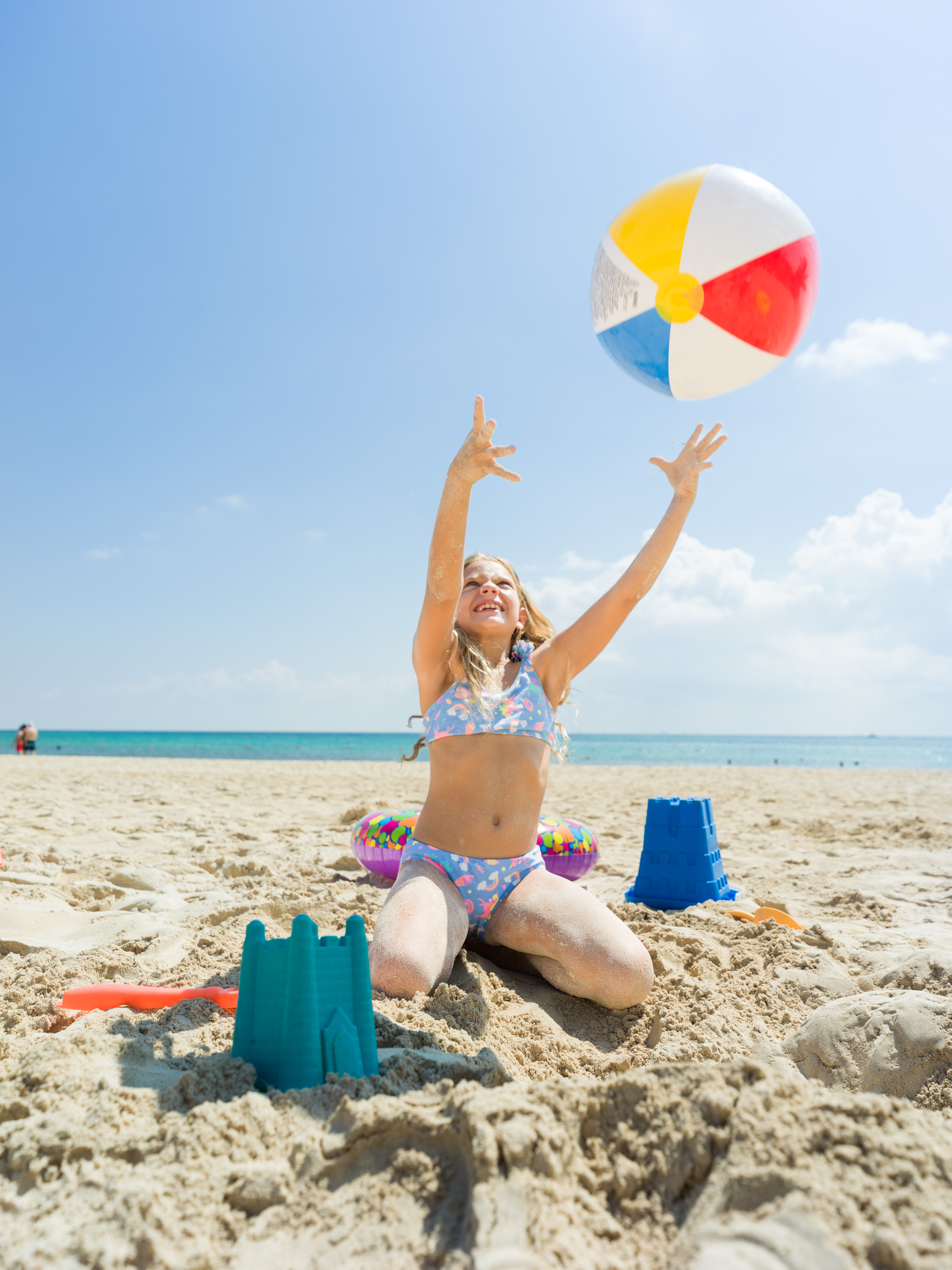 a girl in a garment playing with a beach ball