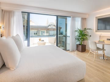 a bedroom with a bed and a table and chairs.