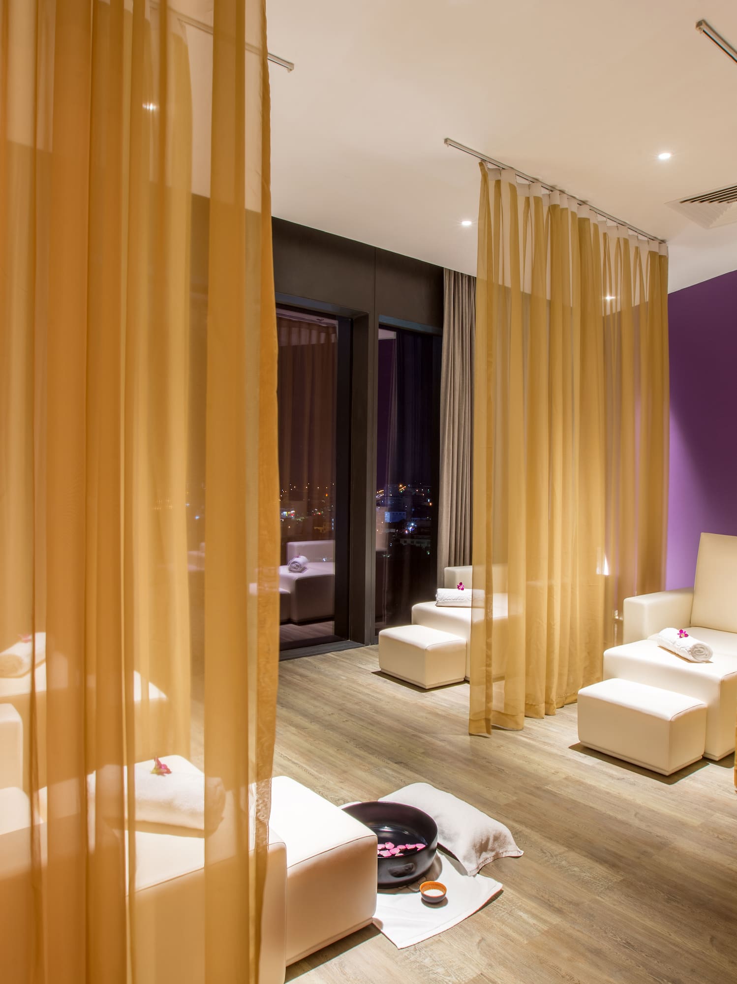 a room with white chairs and yellow curtains