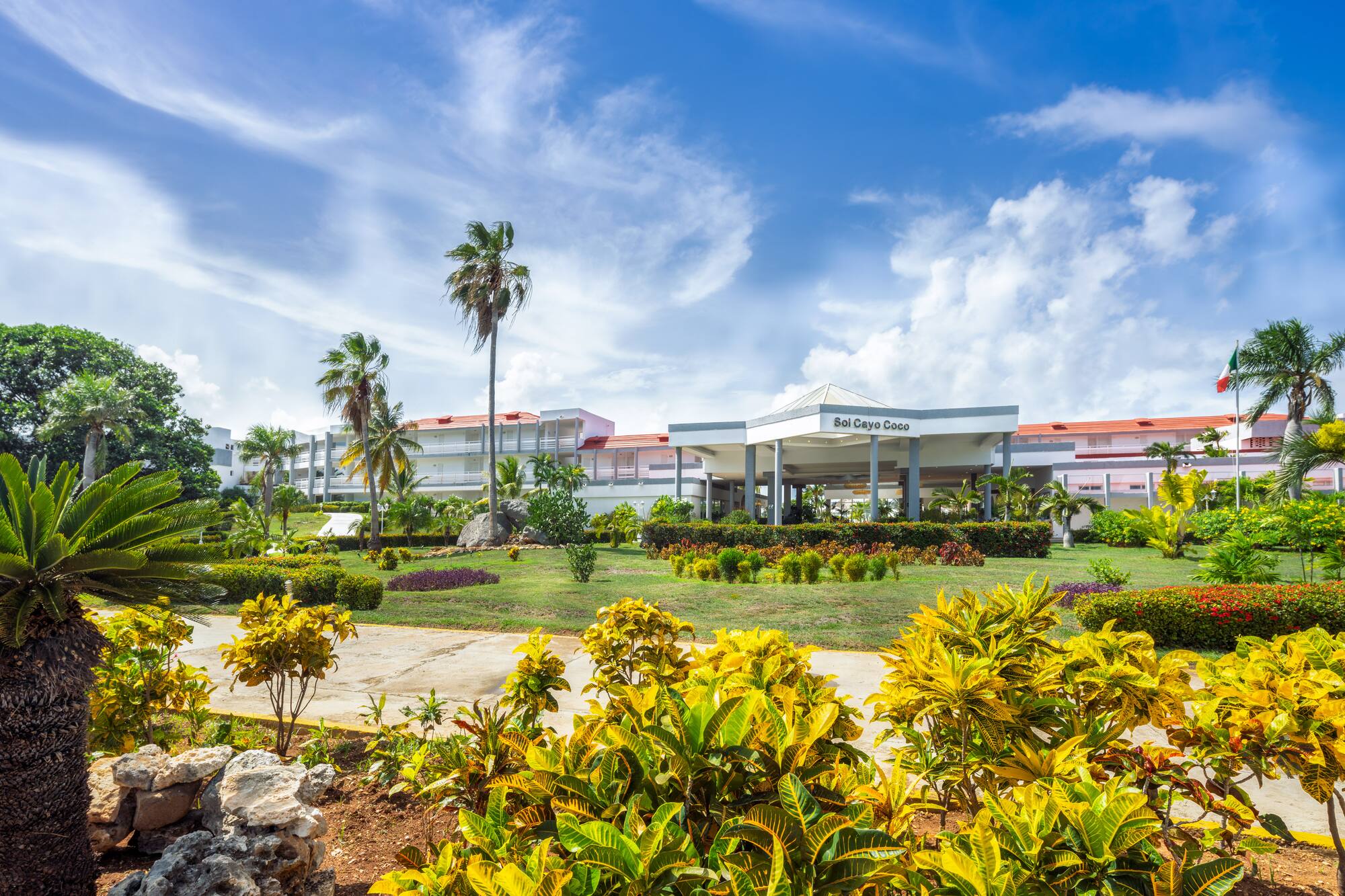 a building with a large front yard and palm trees