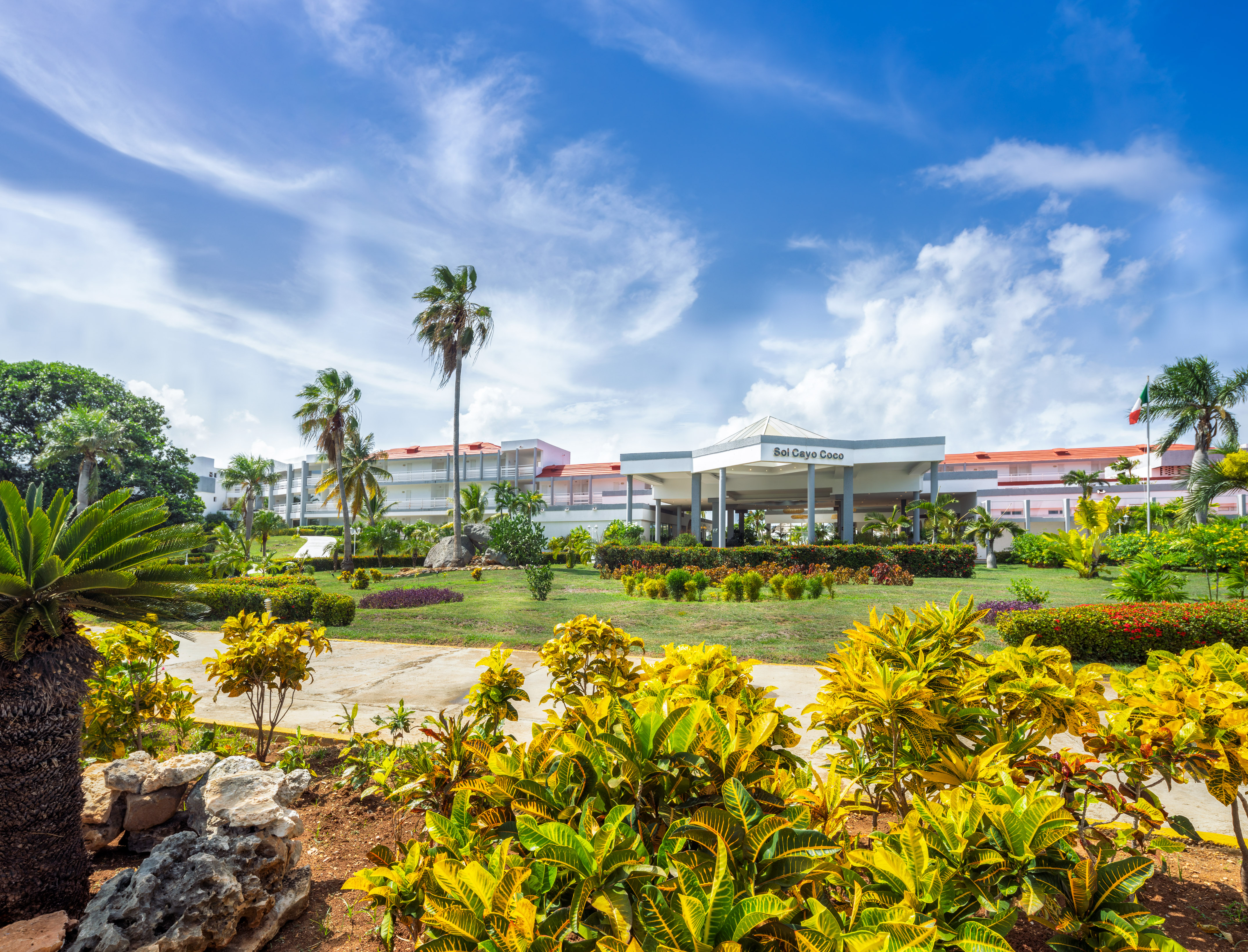 a building with a large front yard and palm trees