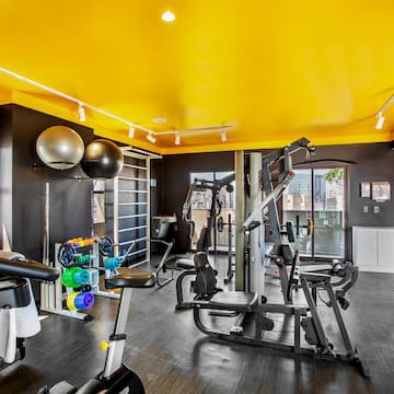 a room with exercise equipment and a yellow ceiling