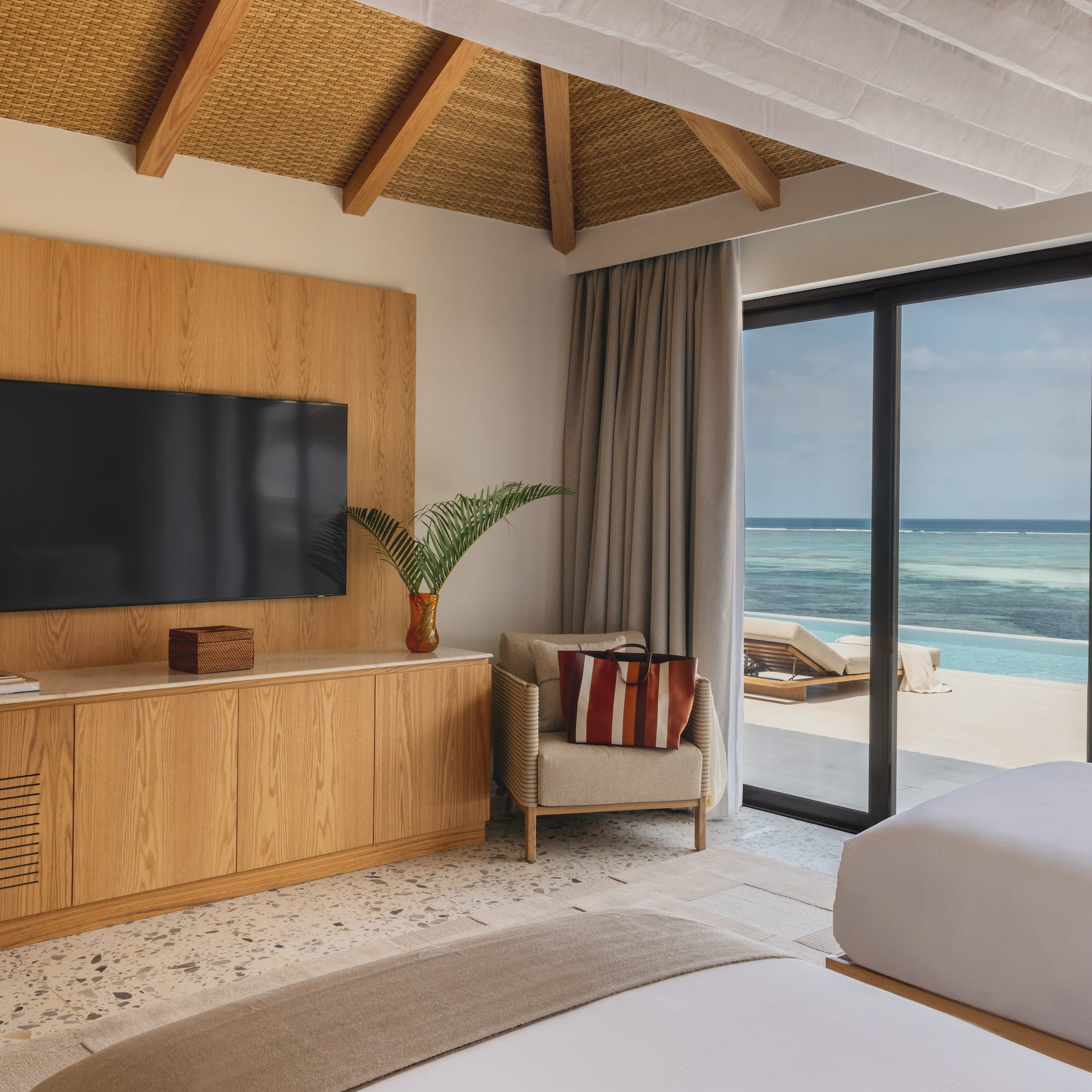 a room with a television and a view of the ocean