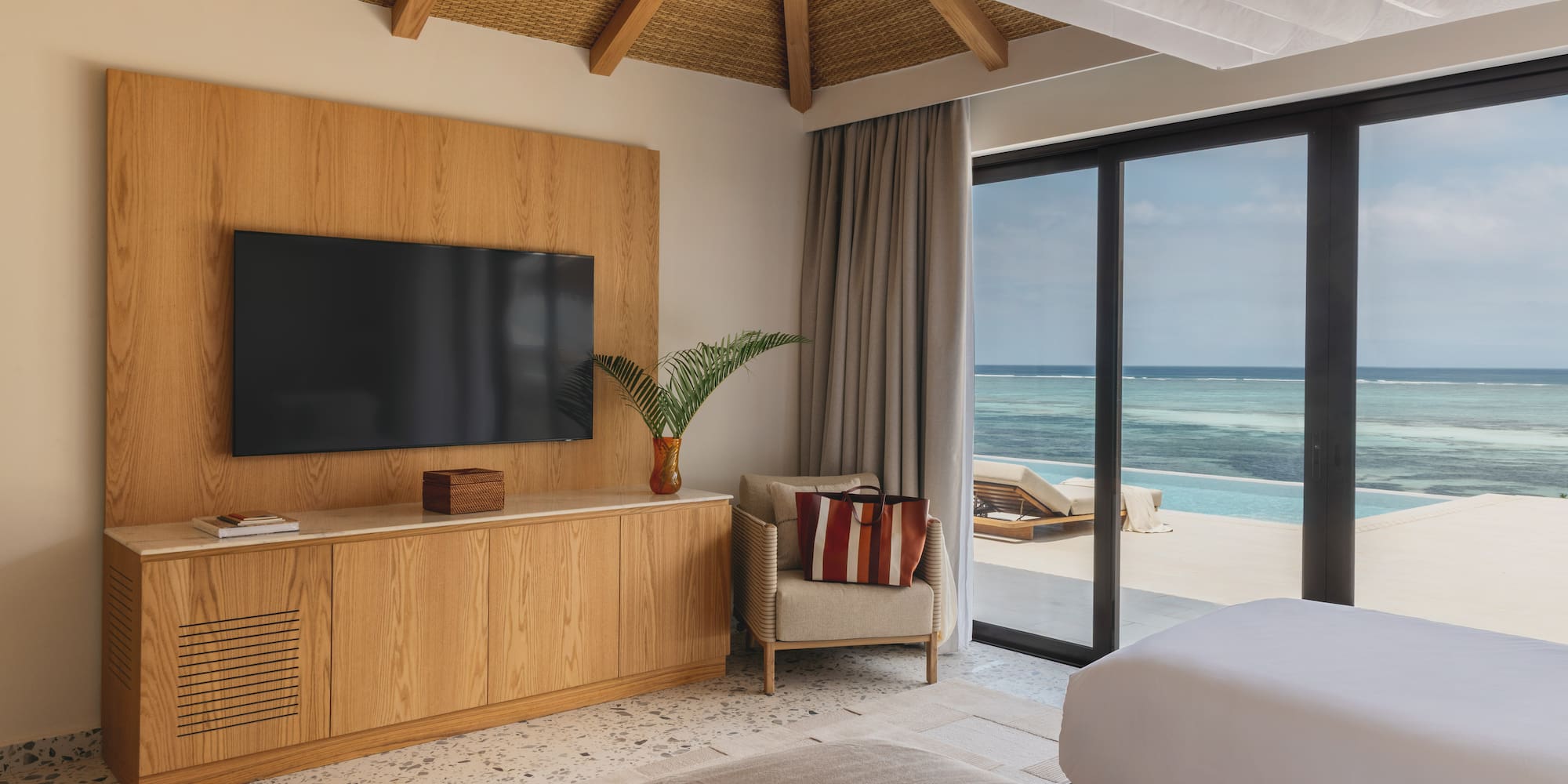 a room with a television and a view of the ocean