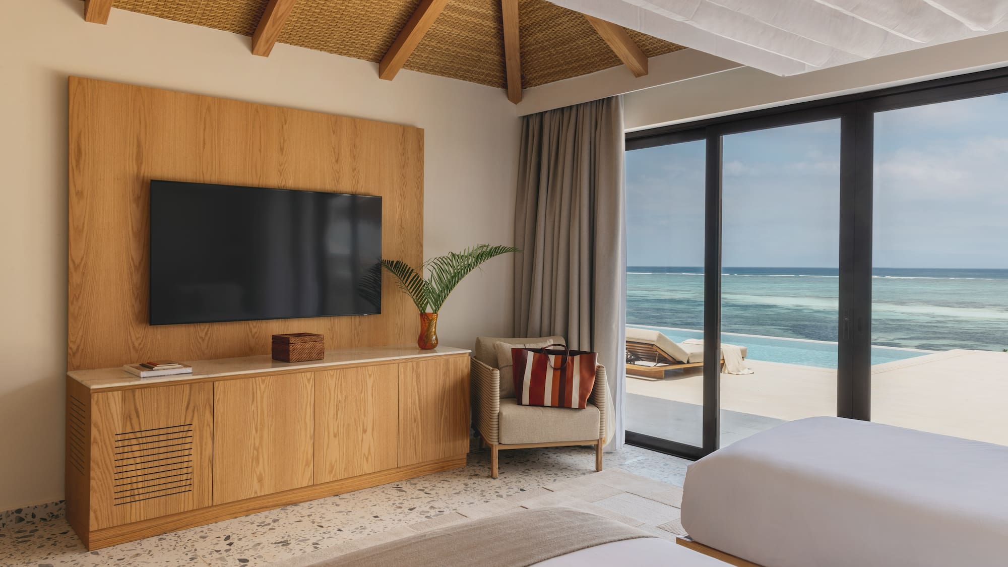 a room with a television and a view of the ocean