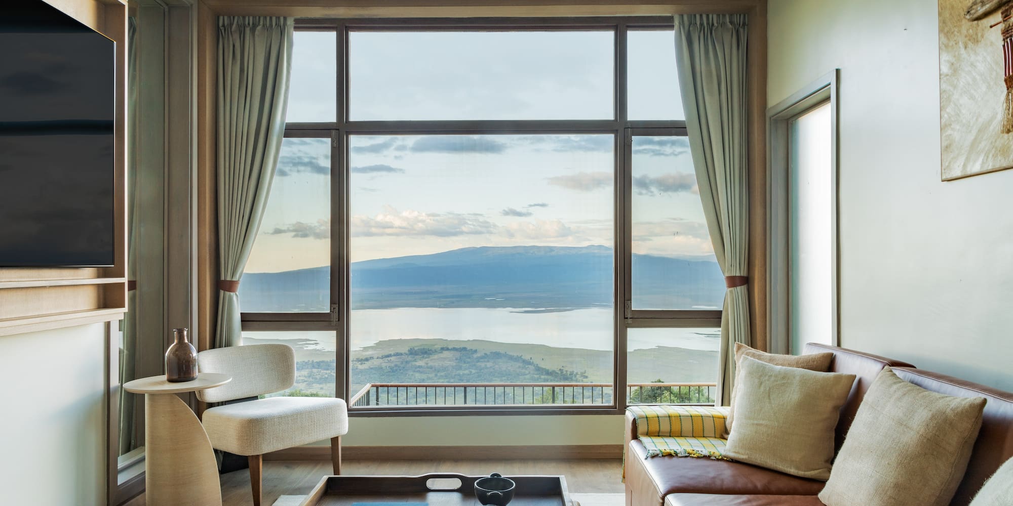 a living room with a view of a lake and mountains