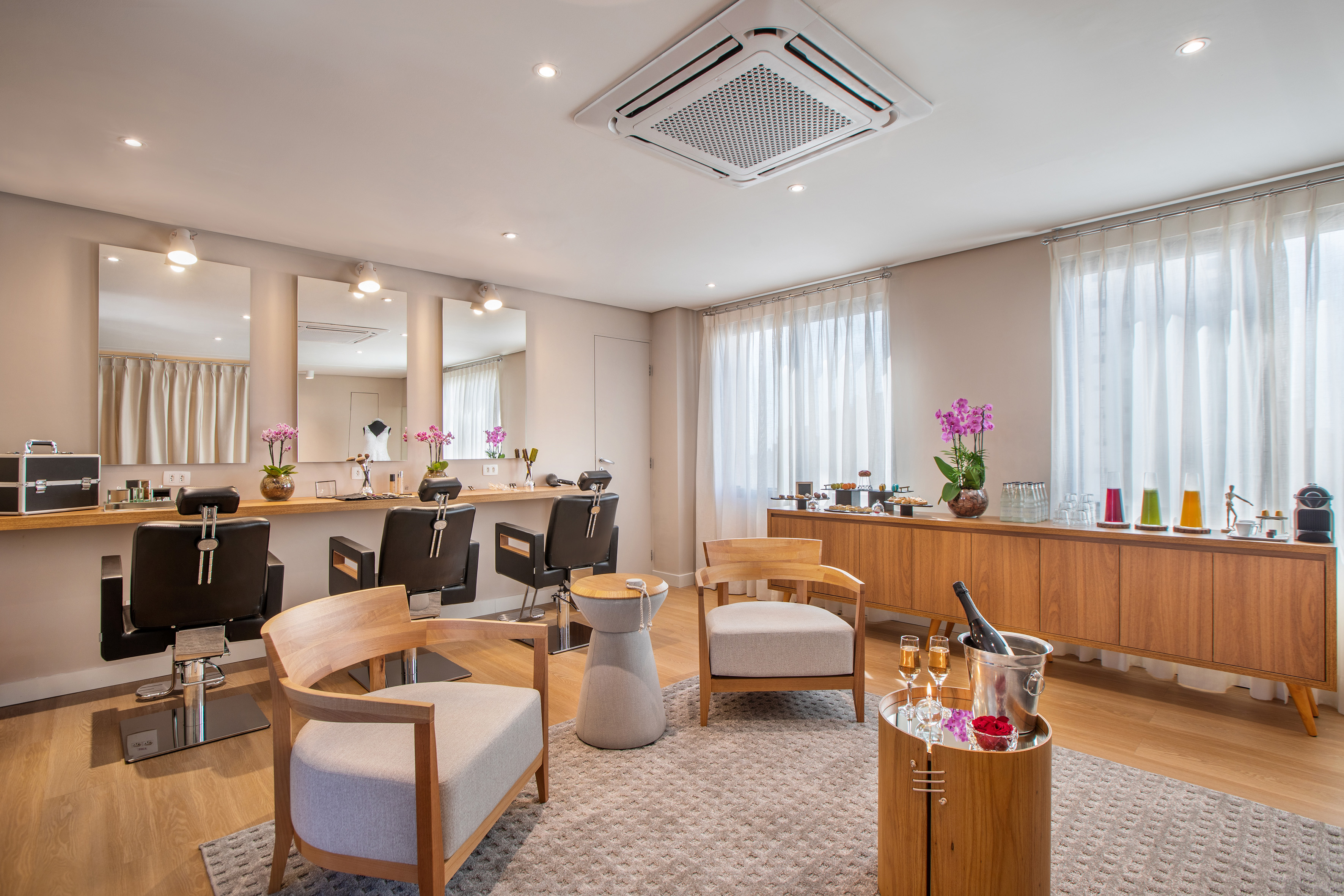 Modern hair salon with styling stations, mirrors, and a lounge area.