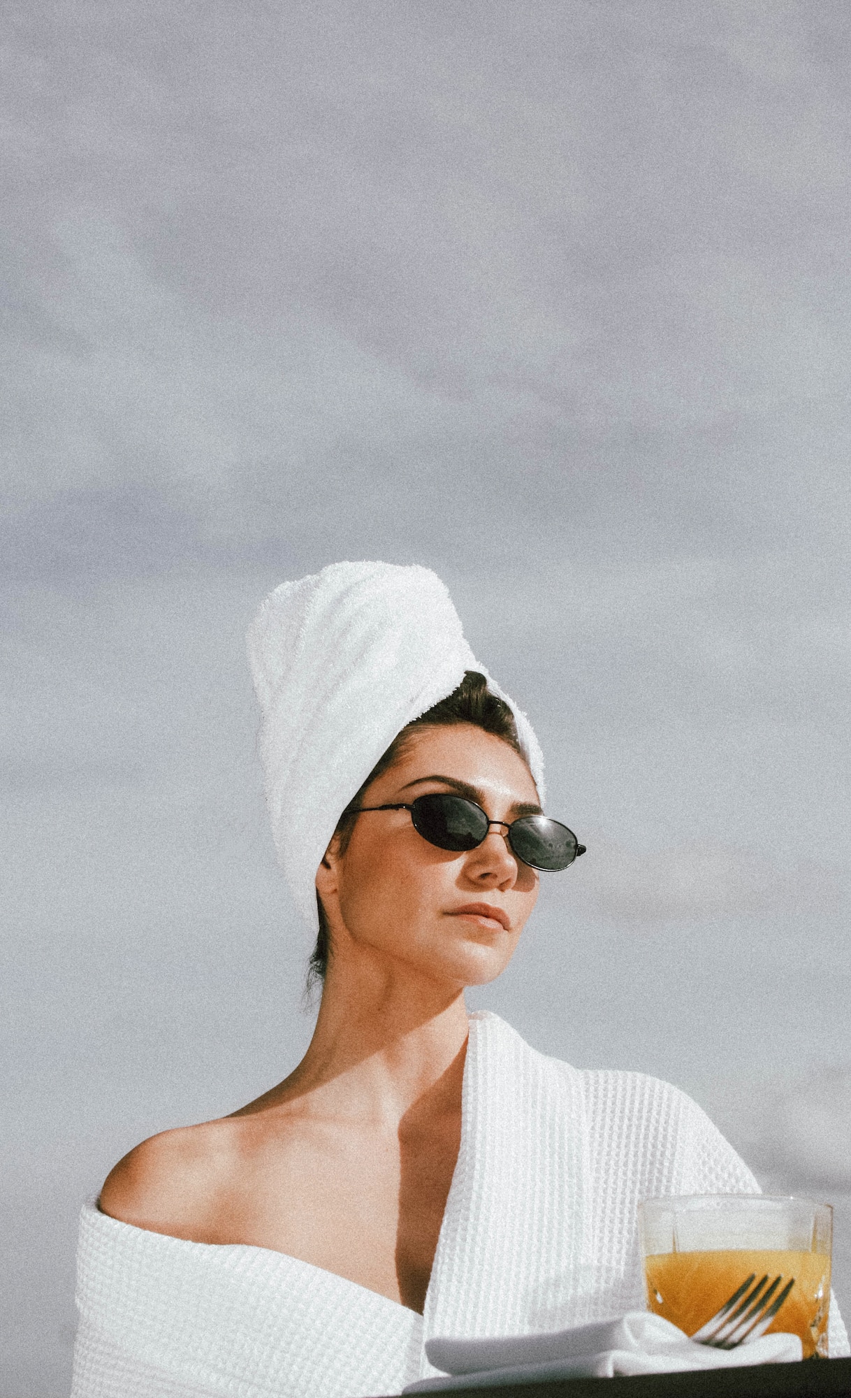 a woman wearing sunglasses and a towel on her head