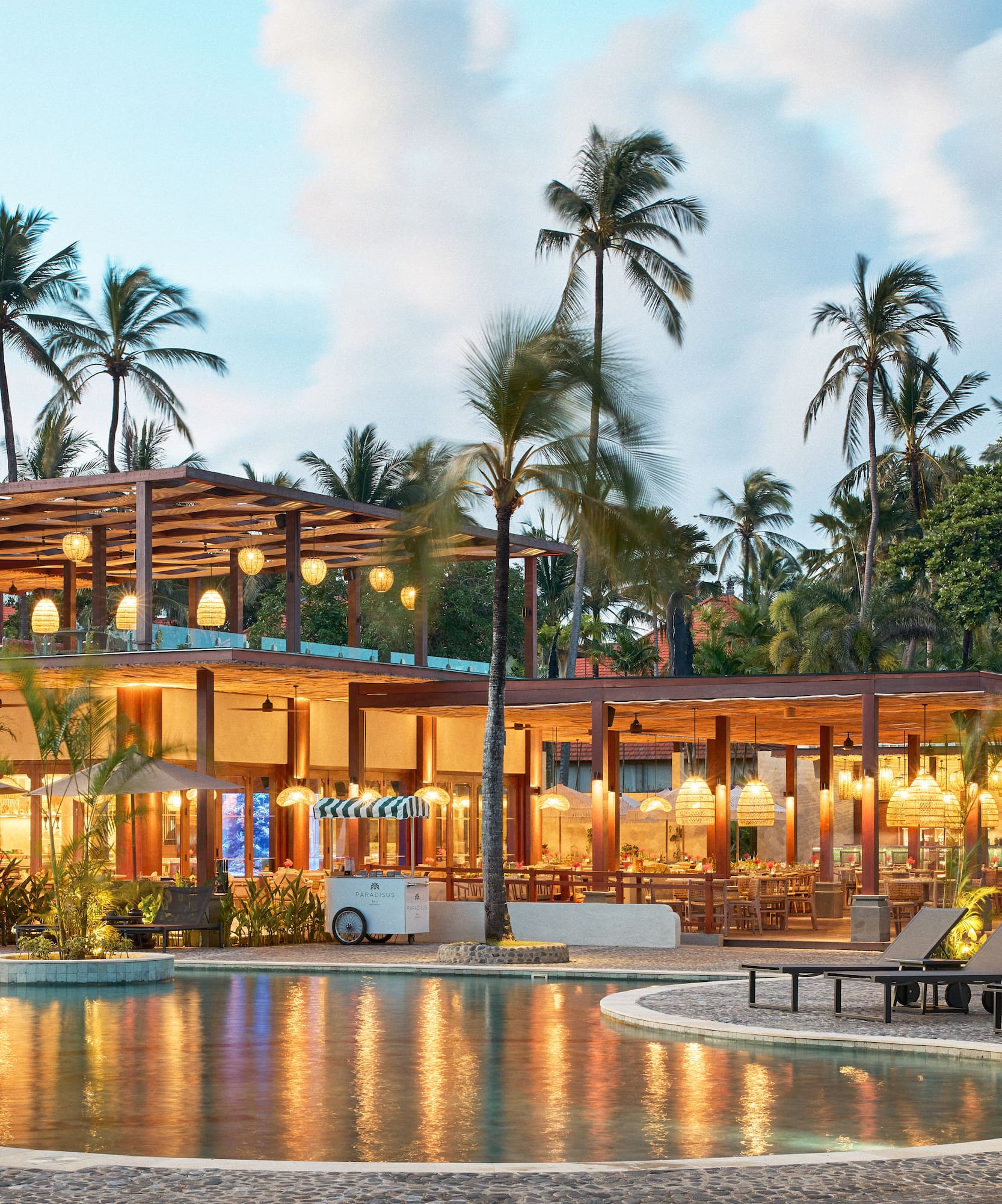 a pool with a building and palm trees