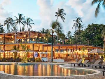 a pool with a building and palm trees