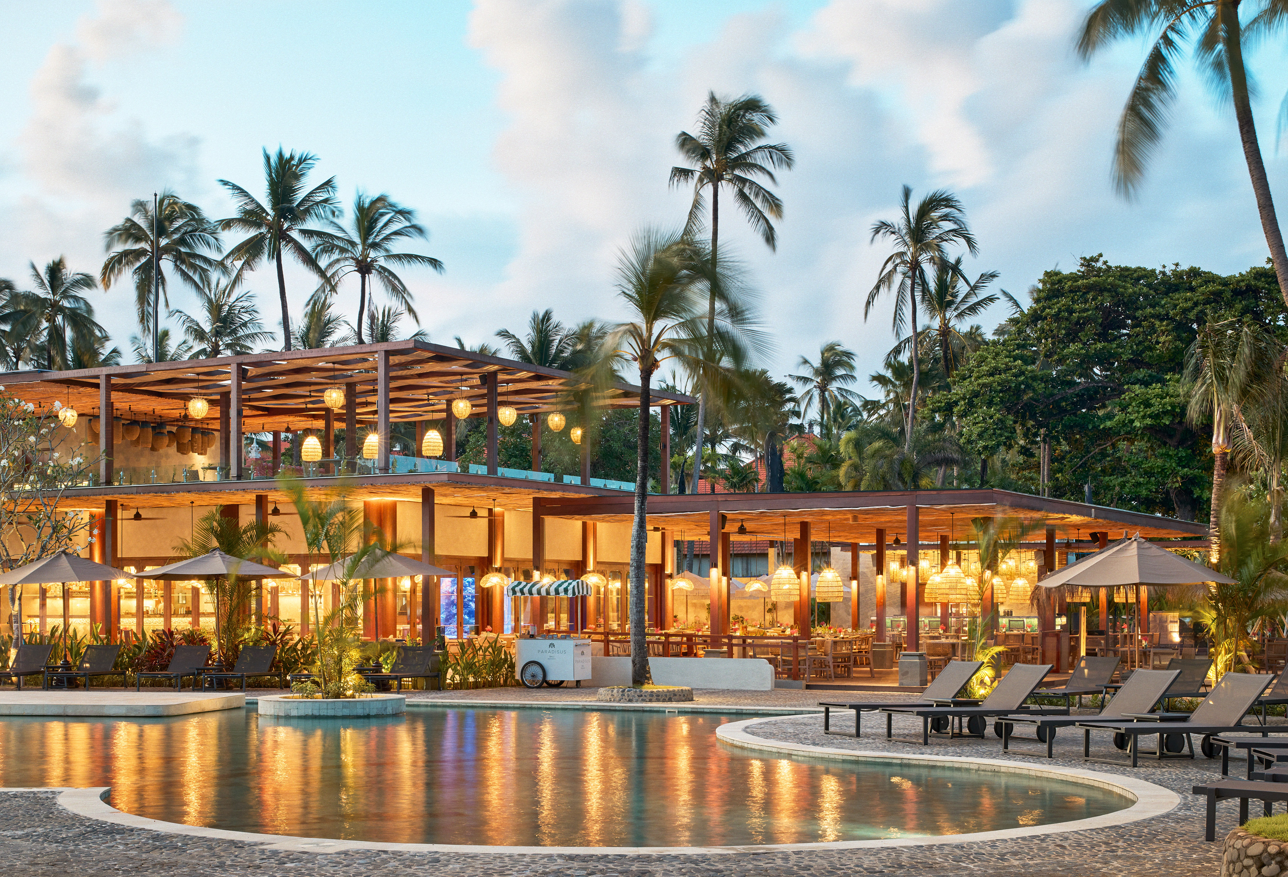 a pool with a building and palm trees