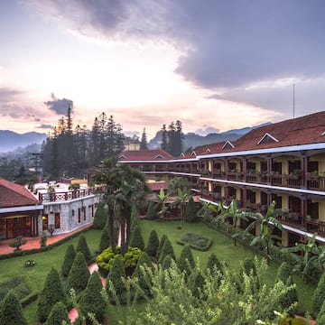 a building with trees and bushes in front of it