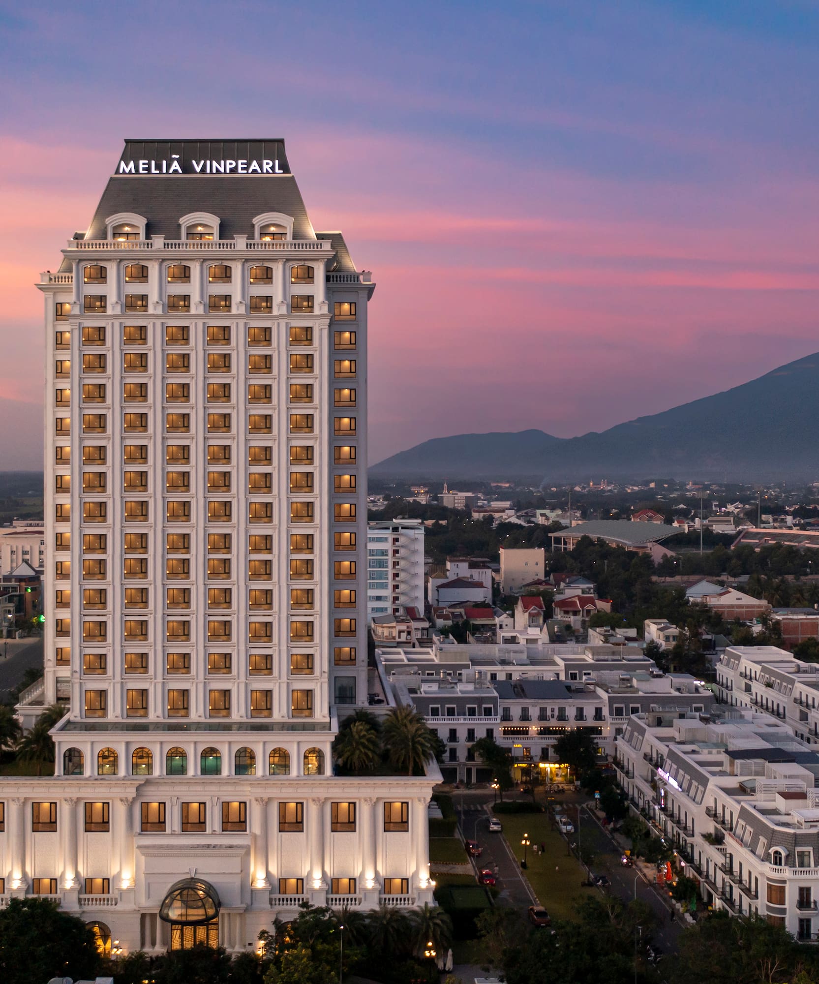 a tall building with many windows with Los Angeles City Hall in the background