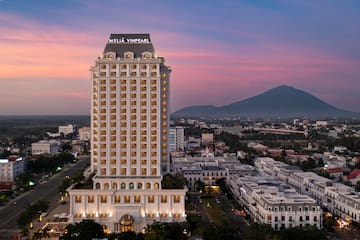 a tall building with many windows with Los Angeles City Hall in the background
