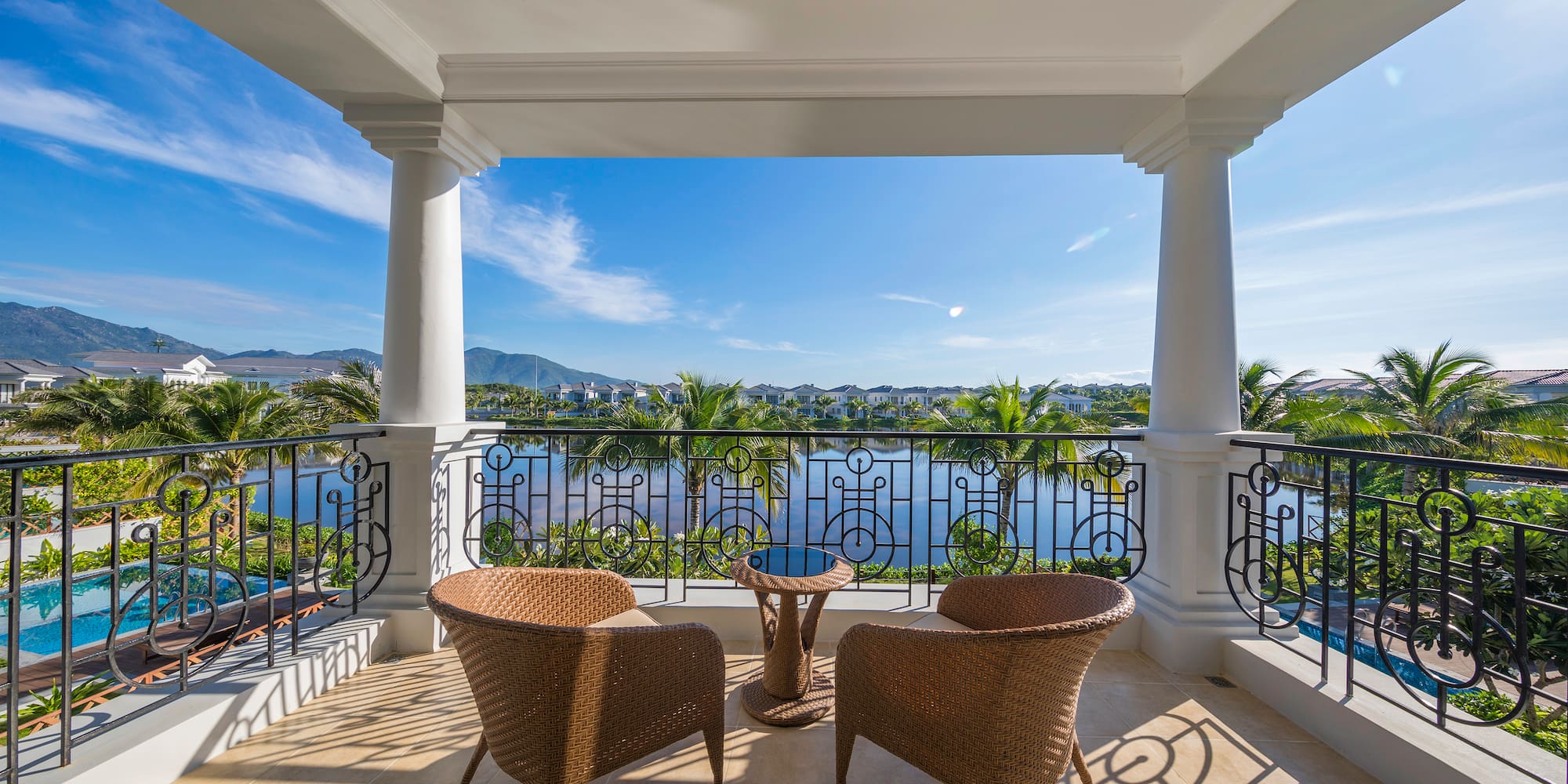 a patio with chairs and a table overlooking a body of water