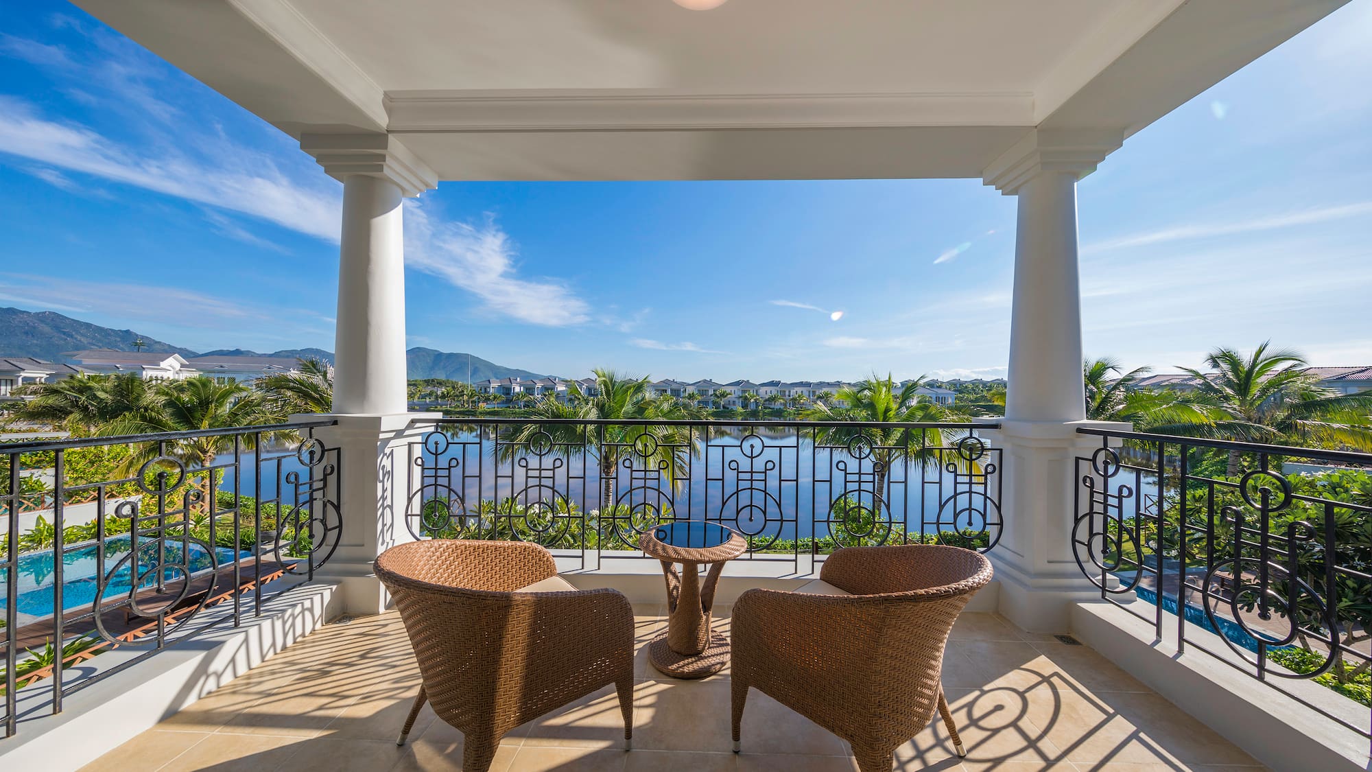 a patio with chairs and a table overlooking a body of water