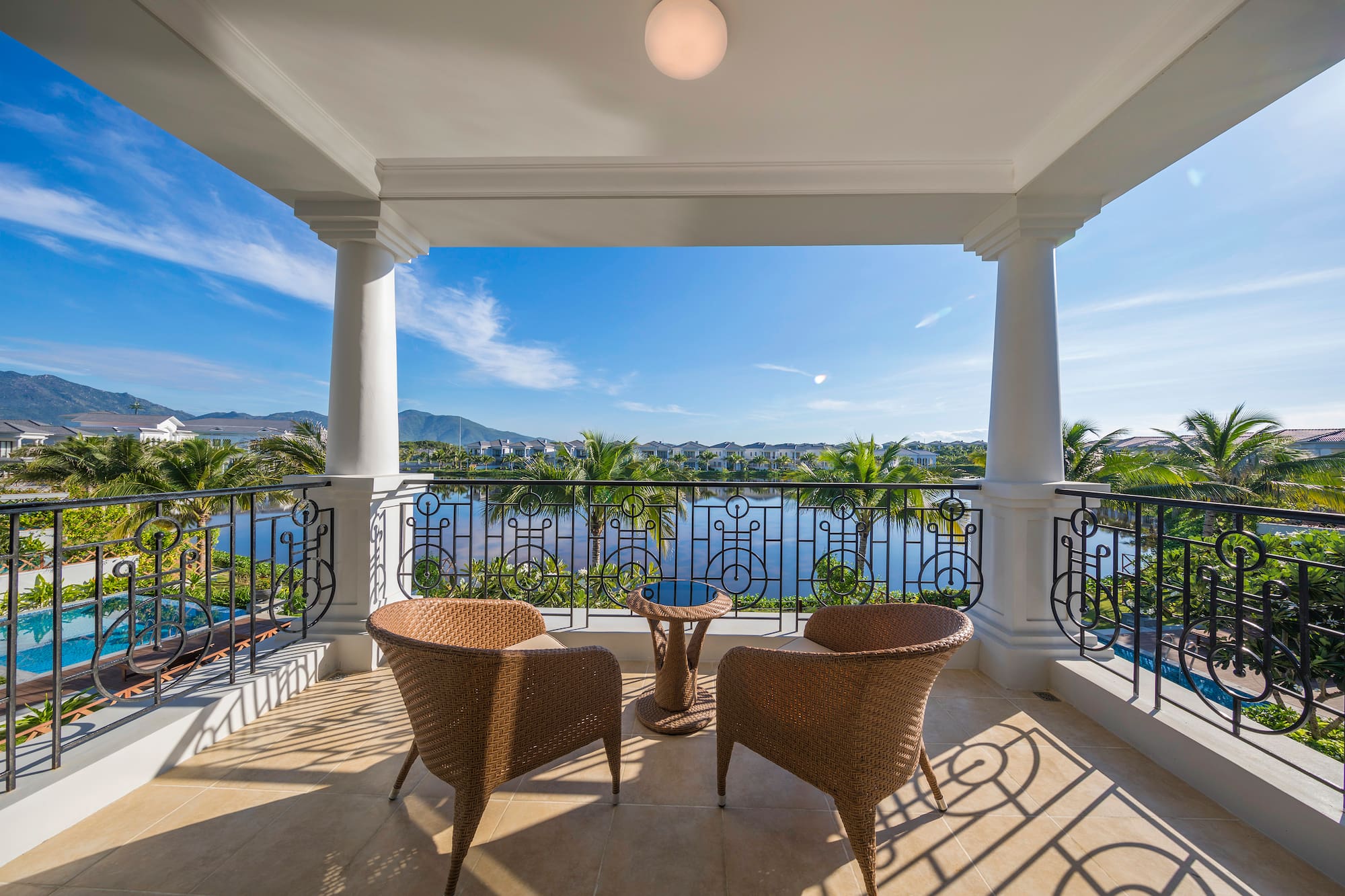 a patio with chairs and a table overlooking a body of water