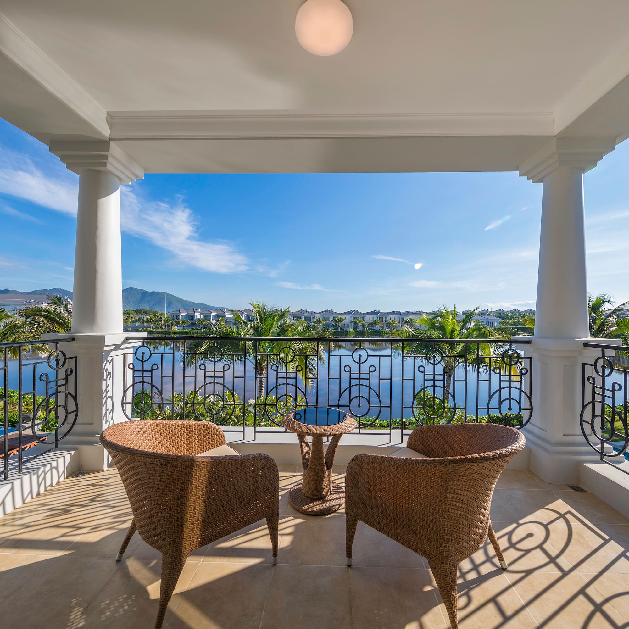 a patio with chairs and a table overlooking a body of water