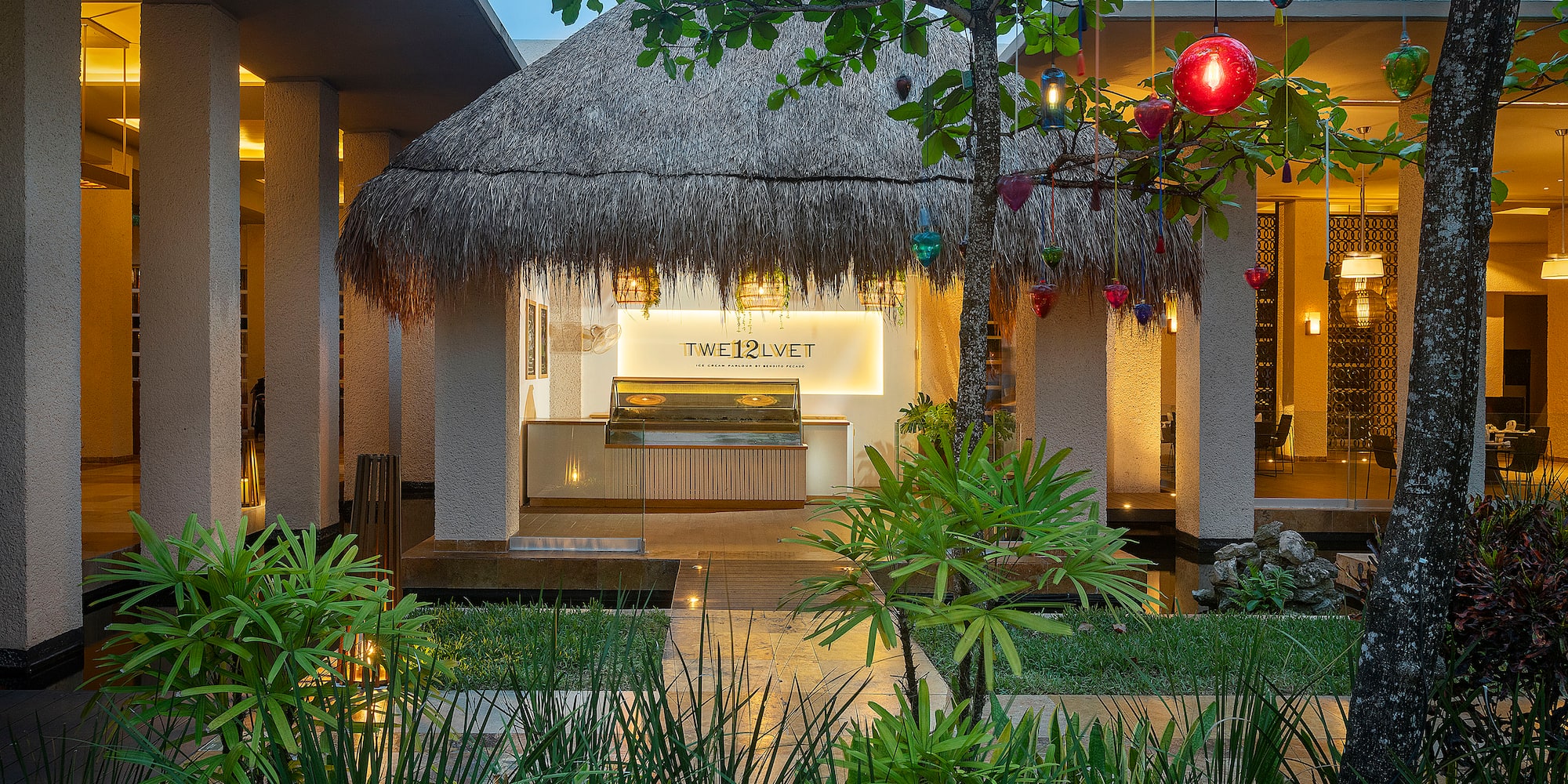 a building with a thatched roof and a palm tree