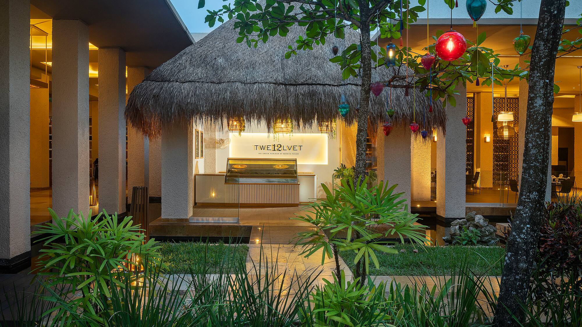 a building with a thatched roof and a palm tree