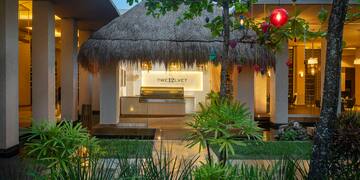 a building with a thatched roof and a palm tree